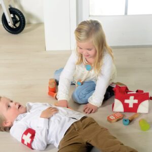 Dokterstas met accessoires zoals stethoscoop en spuit, kinderen spelen zorgzaam rollenspel op de vloer.