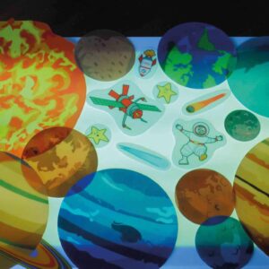 Transparante planeten en ruimtefiguren op een lichttafel, ideaal voor het leren over ons zonnestelsel.