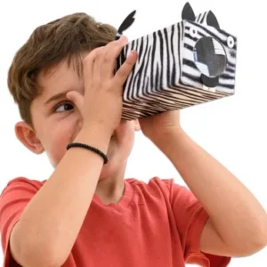 Jongen met een zelfgemaakte telescoop in zebra-stijl, kijkend door het kijkgat, creatief knutselmateriaal zichtbaar.