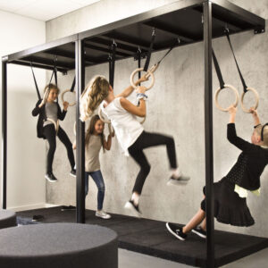 Kinderen spelen op een beweegconcept met ringen, stimuleren motoriek en actieve beweging in een moderne omgeving.