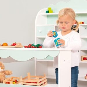 Winkel van Sinkel: houten speelkeuken met pastelgroene details, fruit en groenten, en een kind dat speelt.