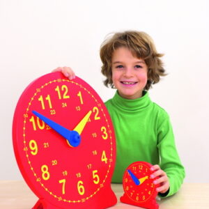 Grote magnetische demonstratieklok van 41 cm met duidelijke cijfers en wijzers, naast een kleinere klok, vastgehouden door...