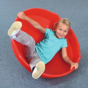 Zitschotel in felrood, met een kind dat erin zit en lachend leunt, stimuleert balans en actieve zithouding.
