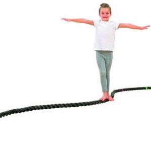 Een meisje balanceert op een flexibel touw, dat in een golvende lijn ligt, en bevordert evenwicht en motoriek.