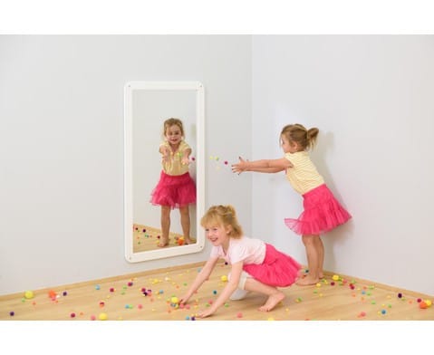 Spiegel met afgeronde hoeken in wit, geplaatst in een speelse ruimte met kleurrijke balletjes en kinderen die spelen.