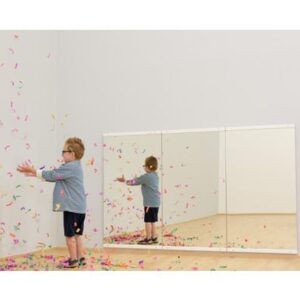 Spiegelwand Verticaal met een kind dat speelt met confetti, weerspiegeld in de verticale spiegels.