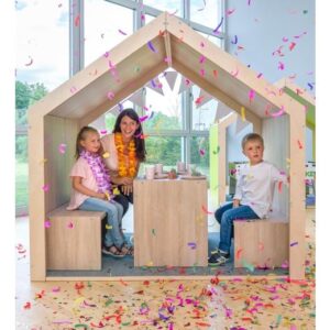 EduCasa Speelhuis XXL in eiken decor met berken multiplex, kinderen spelen binnen met confetti en een tafel.