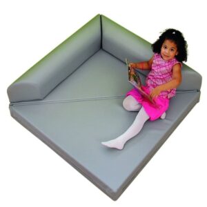 EduCasa Klapdriehoek met rugleuning, multifunctioneel speelelement in grijs, gebruikt als stoel door een meisje met boek.