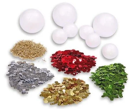 Knutselset met 10 paillettenballen, witte styrofoam ballen en kleurrijke pailletten in rood, groen, goud en zilver.