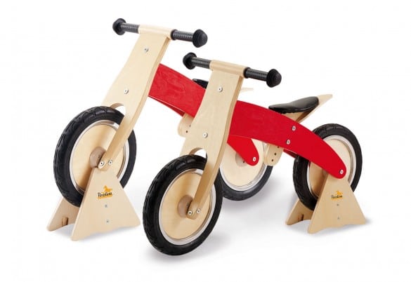 Standaard voor loopfiets in hout met rode en natuurlijke afwerking, geschikt voor kinderen om te leren fietsen.
