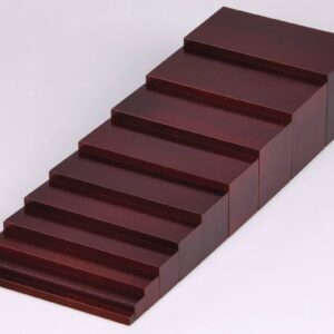 Bruine Montessori trap met tien houten blokken in oplopende maten voor leren over verhoudingen en maten.