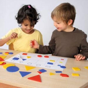 Kleurrijke attribuutblokken set van 60 stuks, kinderen leren sorteren en tellen met vormen op een tafel.