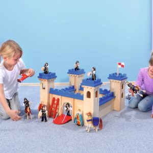 Speelset ridderburcht met torens, muren en poorten, kinderen spelen met figuren en accessoires op een zachte ondergrond.