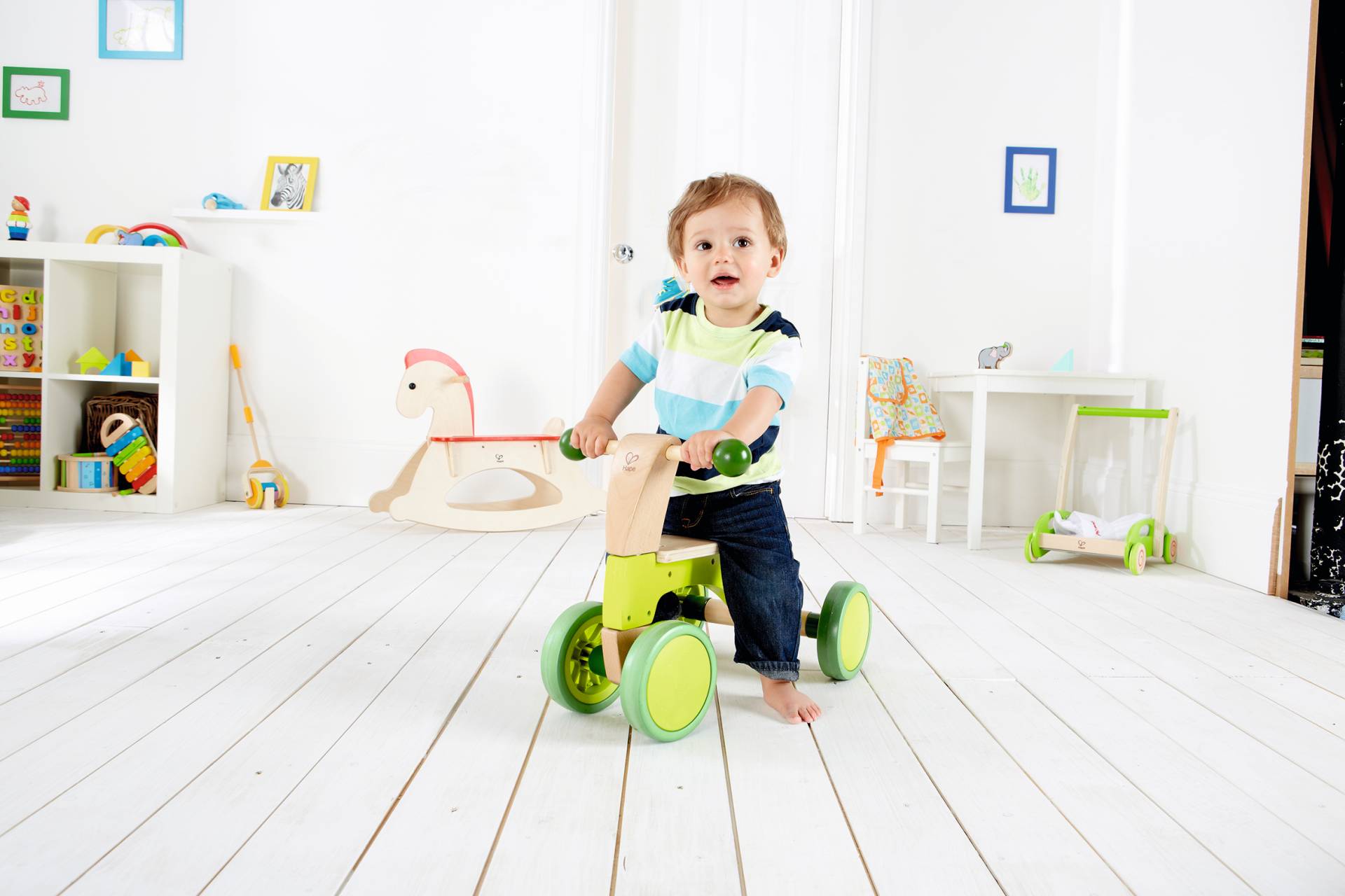 Loopfiets voor jonge kinderen met stevig frame en veilige handgrepen, stimuleert balans en motoriek in speelse omgeving.