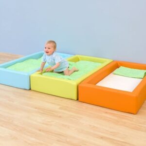 Comfortabel schuimbedje in blauw, groen en oranje, met een kind dat erop kruipt, ideaal voor kinderopvang en peuterruimtes.