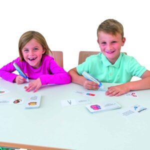 Kinderen gebruiken de Tellimero sprekende pen met kaarten op een tafel, lachend en interactief lerend.