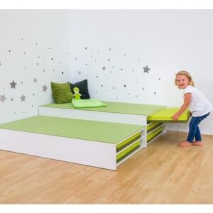 Multifunctionele groene matrassen in een kinderkamer, met opberglades en een meisje dat speelt.