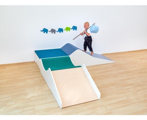 Kleurrijk speelpodium met hellingen, waar een kind met een stok speelt, ideaal voor kinderopvang en spelontwikkeling.