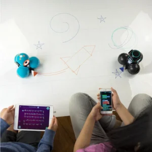 Dash Robot Schets Kit met twee robots op een tekenmat, gebruikers programmeren met tablets en smartphones.