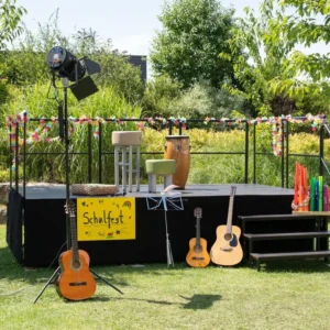 Podium Speedi Vario set met instrumenten en decoraties, eenvoudig op te bouwen en verplaatsbaar, in groene omgeving.