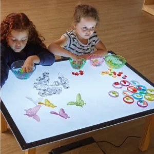 Lichttafel A1 met kinderen die kleurrijke materialen en schalen gebruiken voor spelenderwijs lichtexperimenten.