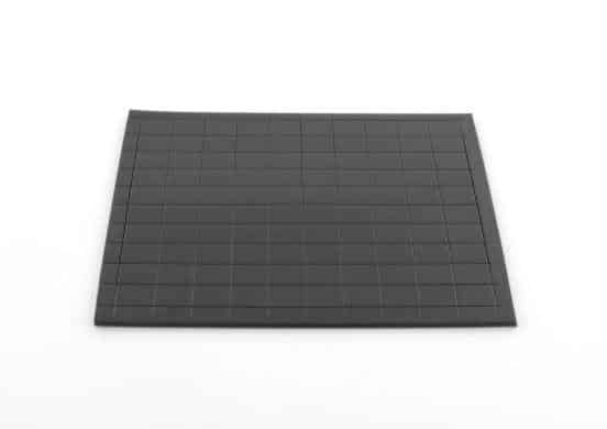 Zwarte magneetstickers van 1 x 1 cm, 100 stuks, op een vlakke ondergrond. Geschikt voor leermiddelen.