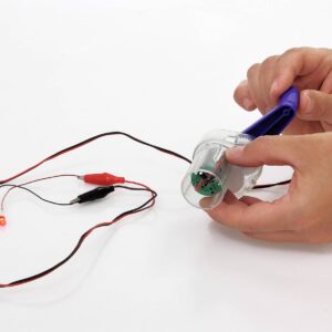 Dynamo met handvat, draden en LED-lampje; toont omzetting van beweging in elektriciteit.