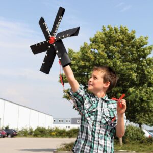 Jongen met een windmolenmodel in de hand, leert over alternatieve energiebronnen buiten.