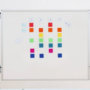Ritme- en tijdkaarten voor Boomwhackers op een magnetisch bord, met kleurrijke blokken en nummers.