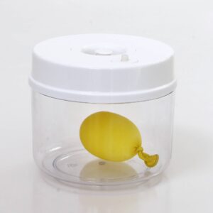Vacuümkamer met een doorzichtige container en een gele ballon erin, ontworpen voor wetenschappelijke experimenten.