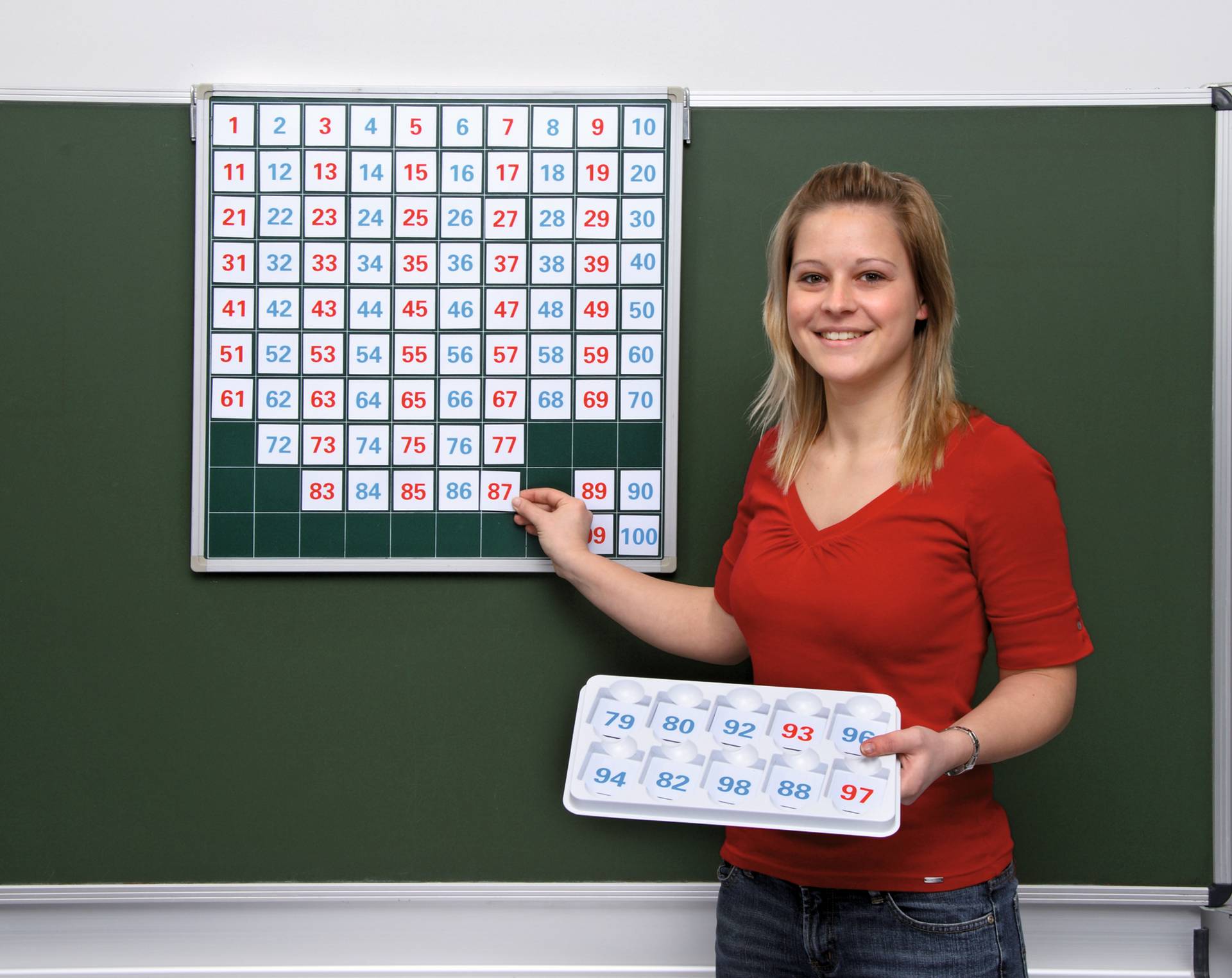 Magnetisch bord van 60x60 cm met 100 vlakken en een vrouw die cijfers van 1 tot 100 toont op kaartjes.
