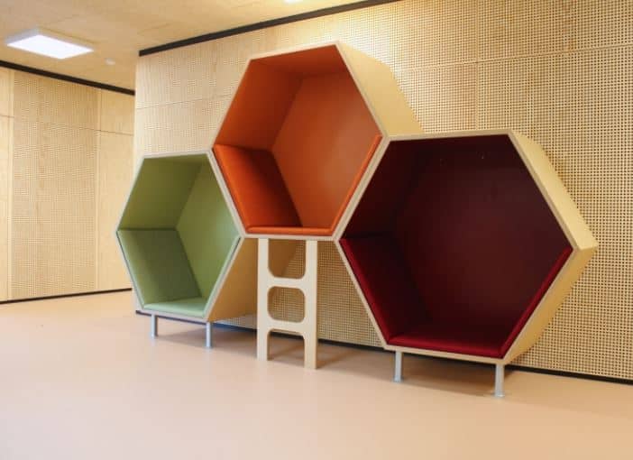 Zeshoekige nissen in groen, oranje en rood met trapje, geschikt voor kinderopvang en speelhoeken.