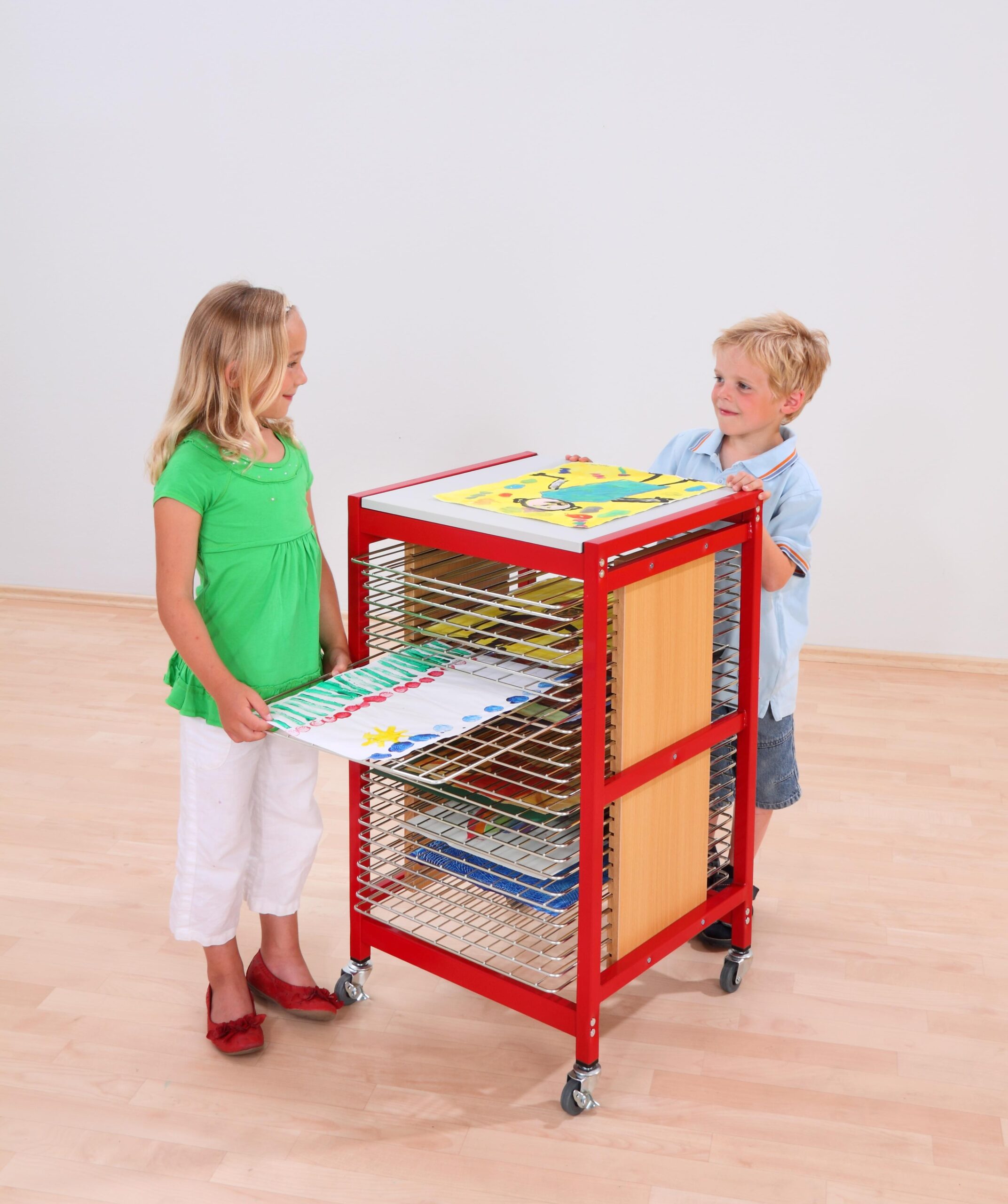 Droogrek A2 met 25 planken, rood met houten panelen, gebruikt door twee kinderen voor het drogen van kunstwerken.