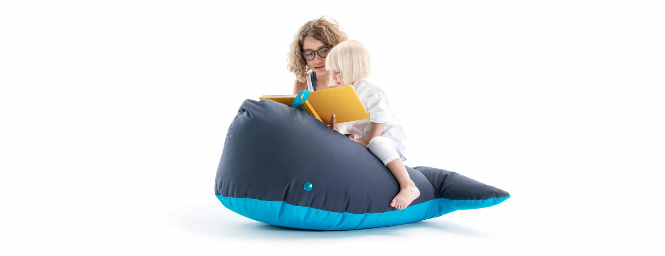 Knuffelbare walvis in zachte stof, perfect om op te zitten, met een kind dat leest. Ideaal voor speel- en leeromgevingen.