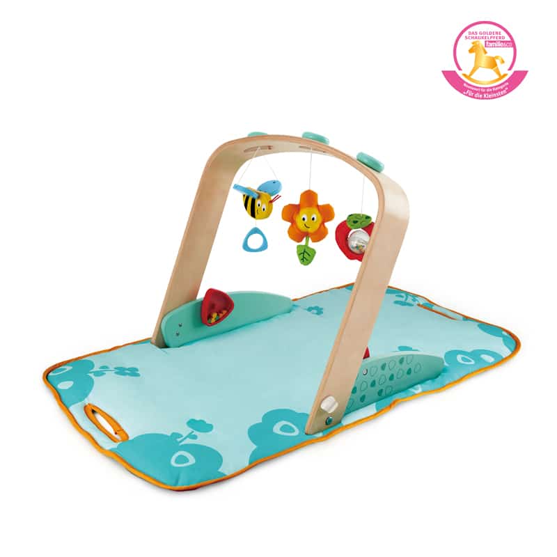 Houten Babygym Hape met kleurrijke hangspeeltjes en een zacht speelkleed voor zintuiglijke ontwikkeling van babys.