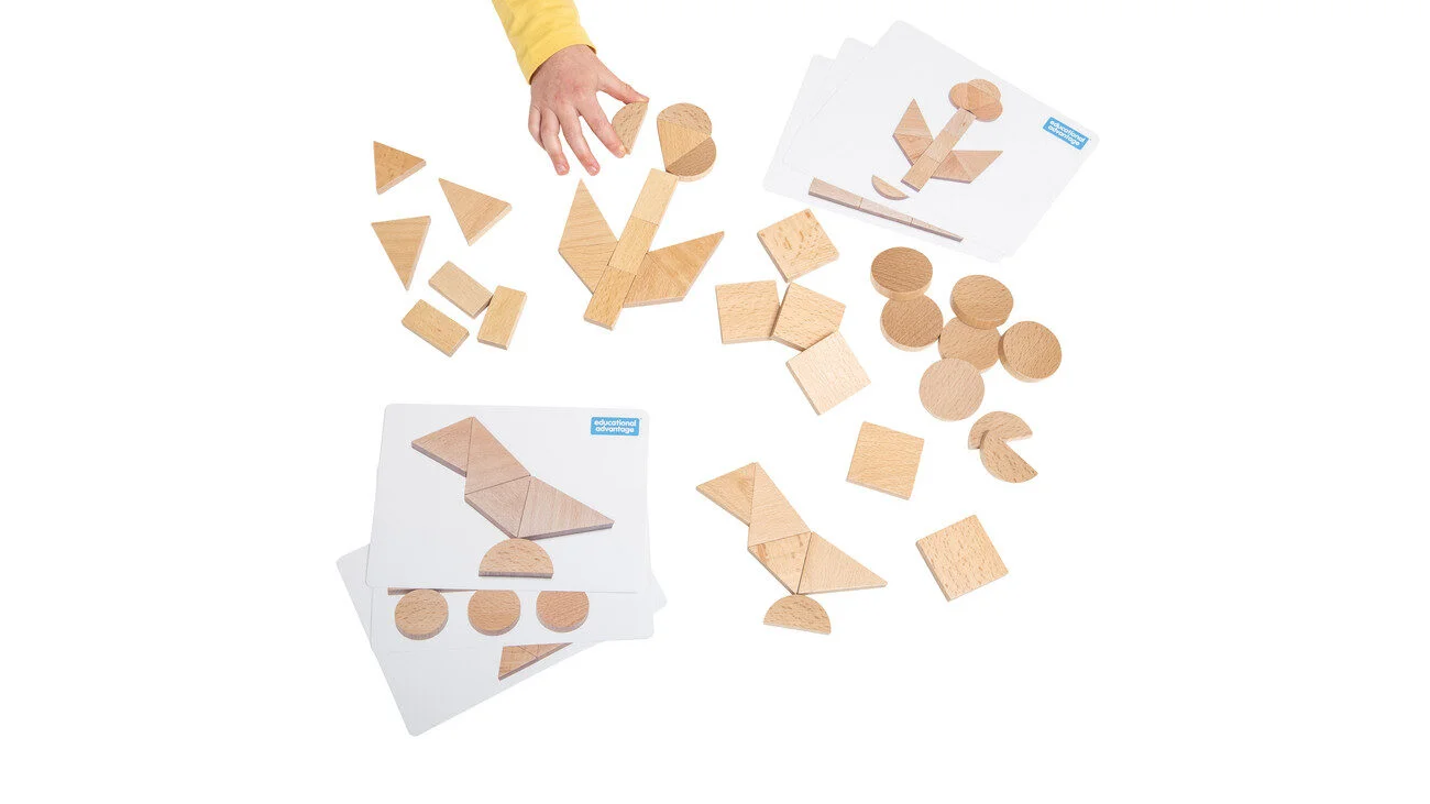 Natuurlijke houten legmallen in verschillende vormen, met hand die een stuk vasthoudt, op witte achtergrond.