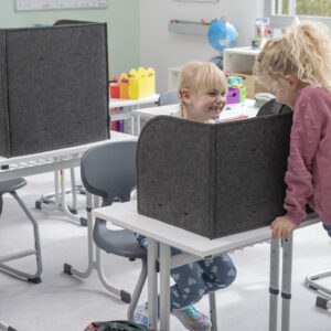 Opvouwbaar concentratiescherm in een klaslokaal, met kinderen die erachter zitten, biedt een prikkelarme leeromgeving.