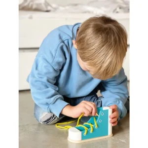Kinderen leren veters strikken met de Bindlint Rijgen Schoenen, kleurrijk en houten basis voor fijne motoriek.