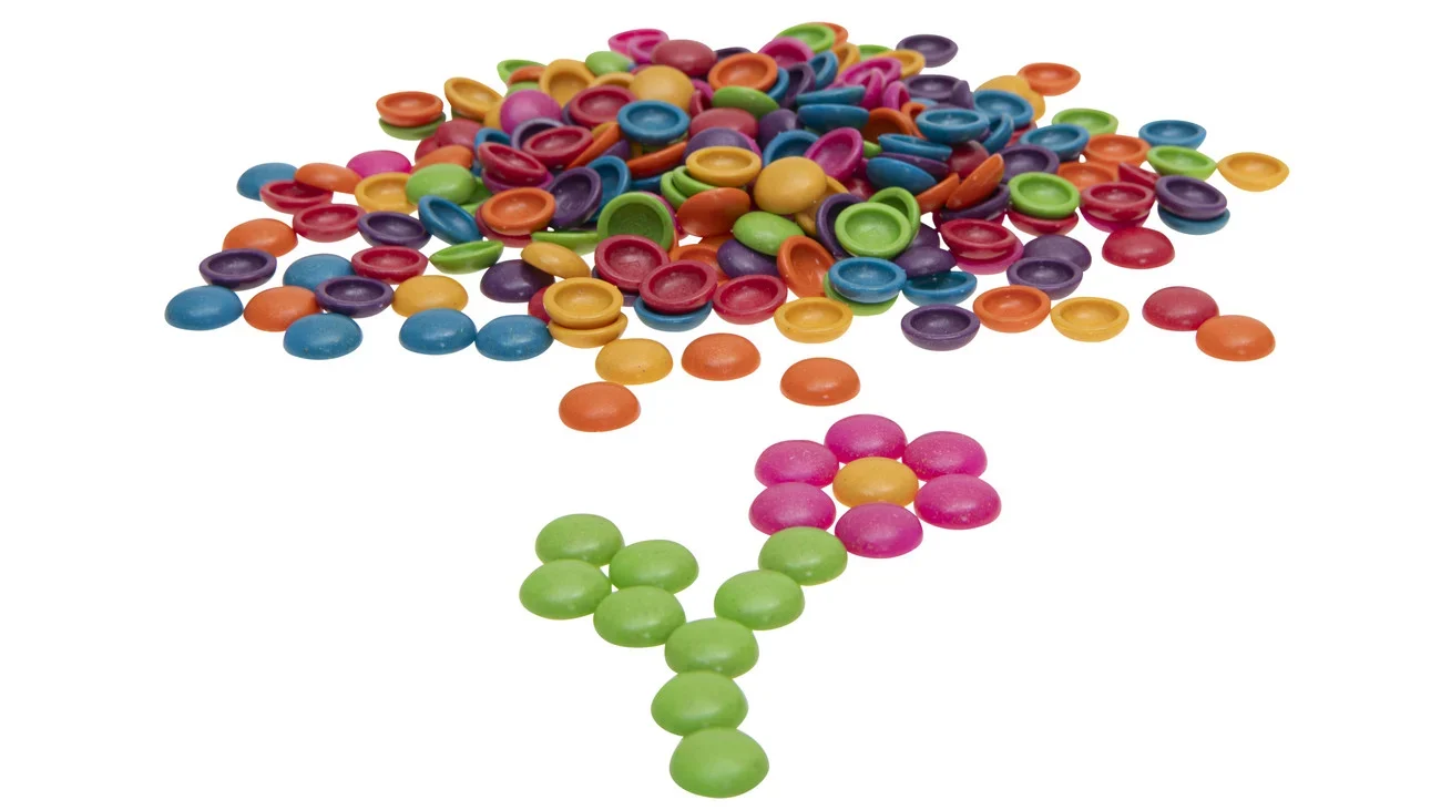 Kleurige Dreuzelstenen in diverse kleuren, Ø 20 mm, verspreid met een bloemvormige creatie in het midden.