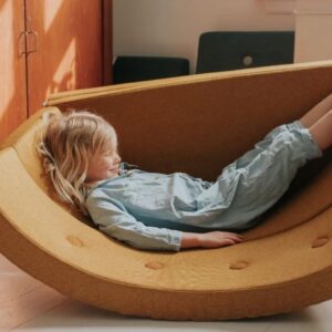 Multifunctioneel DK - PLAY Fold Circle meubel in een warme gele kleur, met een kind dat ontspannen ligt met benen omhoog.