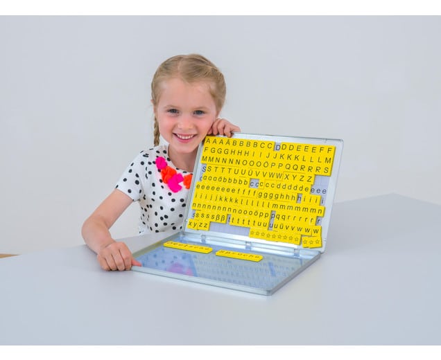 Magnetische letterdoos met 230 letters, jokers en spaties, gebruikt door een meisje met een vrolijke outfit.