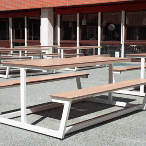 Robuuste stalen outdoor picknicktafels met houten blad, geplaatst op een buitenplein, ideaal voor rust- en overlegplekken.