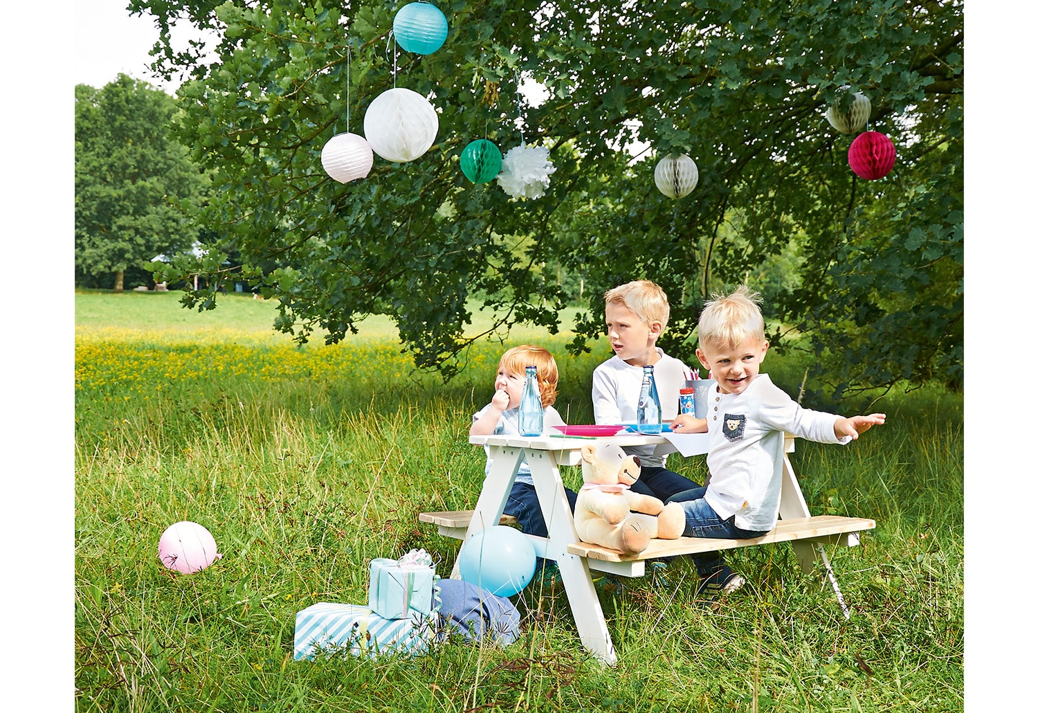 Witte picknicktafel voor kinderen met comfortabele zithoogte van 28 cm, geschikt voor 4 kinderen, in een groene omgeving.