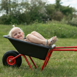 Roze kruiwagen met één wiel, kunststof bak en rubberen handgrepen, ideaal voor kinderen om mee te spelen.