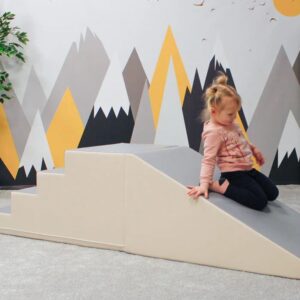 Glijbaan SoftPlay met trapje, zacht en licht, ideaal voor fantasierijk spel in kinderopvang. Kind speelt erop.