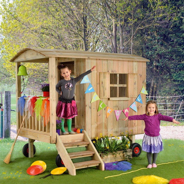 Vrolijke houten circuswagen met kinderen, versierd met kleurrijke slingers en accessoires, uitnodigend tot spel en fantasie.